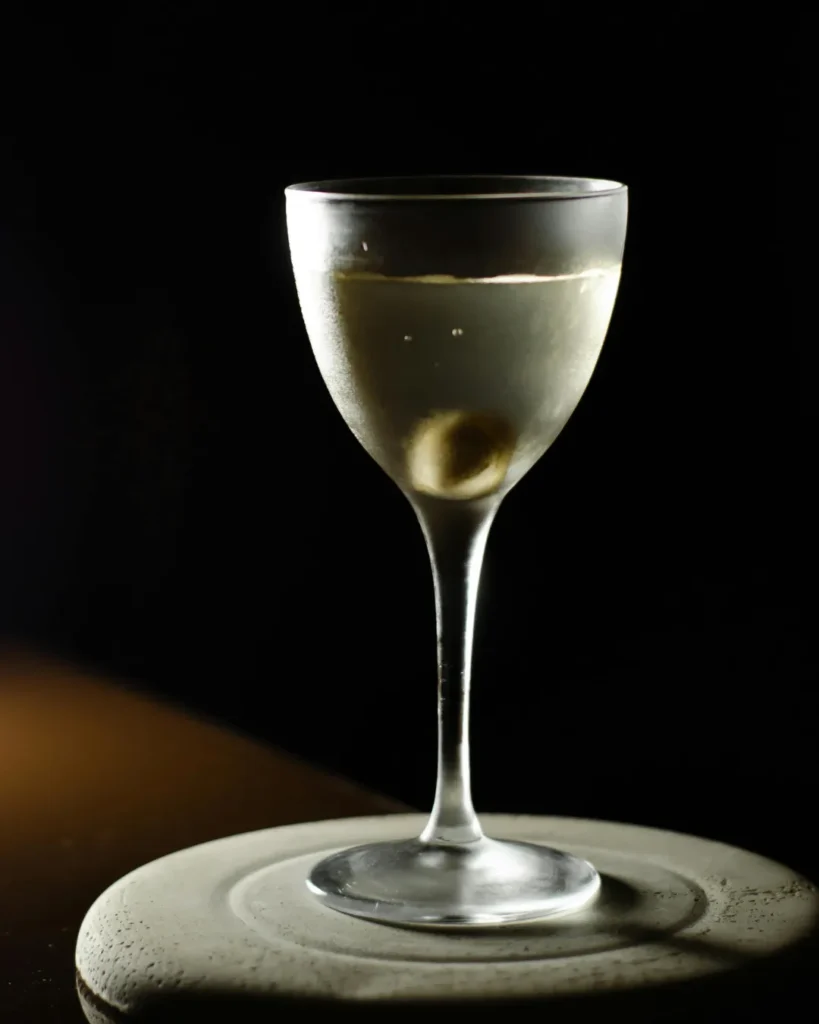 Copa de Martini helada con un Montgomery Martini minimalista, destacando la transparencia del cóctel y el detalle del tallo de la copa.