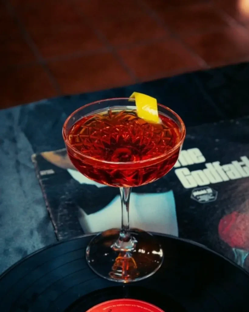 Negroni Sbagliato con rodaja de naranja; el famoso 'Negroni equivocado' que el Harry's Bar de Venecia popularizó como el aperitivo de lujo definitivo.