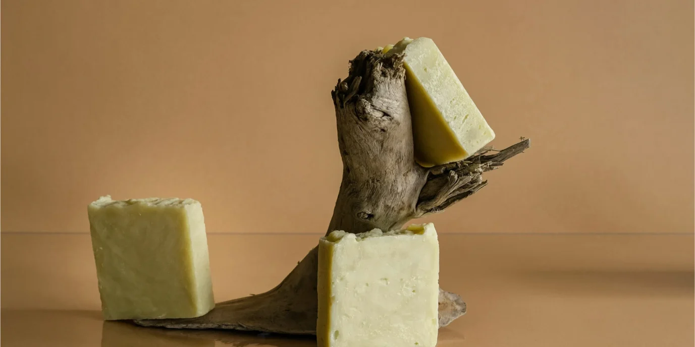 Primer plano de bloques de mantequilla artesanal con cristales de sal sobre una base de madera oscura, estilo fotografía editorial.