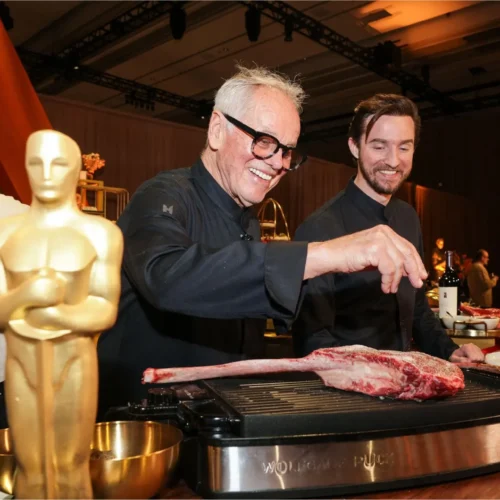 Aquí tienes un texto ALT optimizado para SEO, que es descriptivo y relevante para el contexto actual (marzo 2026, temporada de premios): "El chef Wolfgang Puck preparando los platillos del menú oficial para la gala de los Premios Oscar 2026 en Los Ángeles.