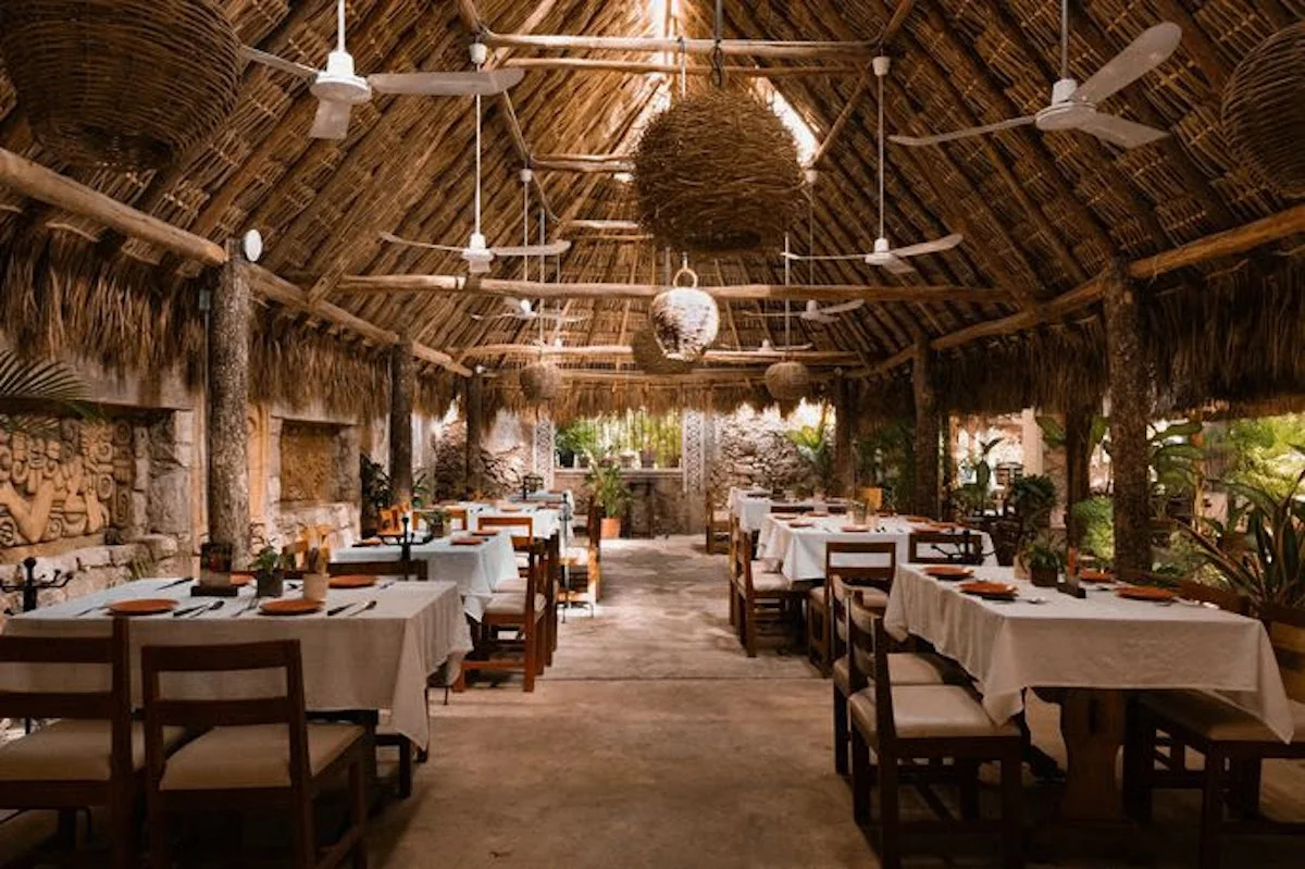 Interior del restaurante Kinich en Izamal, Yucatán, con arquitectura tradicional, mesas de madera y ambiente inspirado en la cultura yucateca.