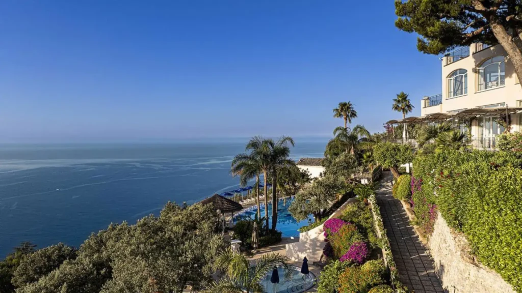 Vista panorámica desde la terraza del Hotel Raito, mostrando las piscinas de borde infinito que se funden con el azul del Golfo de Salerno y los acantilados de Vietri sul Mare.