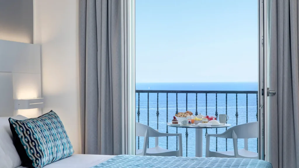 Vista desde una habitación del Lloyd's Baia Hotel en la entrada de la Costa Amalfitana, mostrando los acantilados de Vietri sul Mare y el azul profundo del Golfo de Salerno.