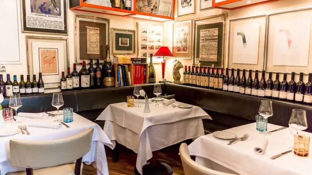Fachada acogedora de la Osteria Canali en un callejón histórico de Salerno, con mesas de madera y un ambiente rústico típico de las tabernas tradicionales de la Campania.