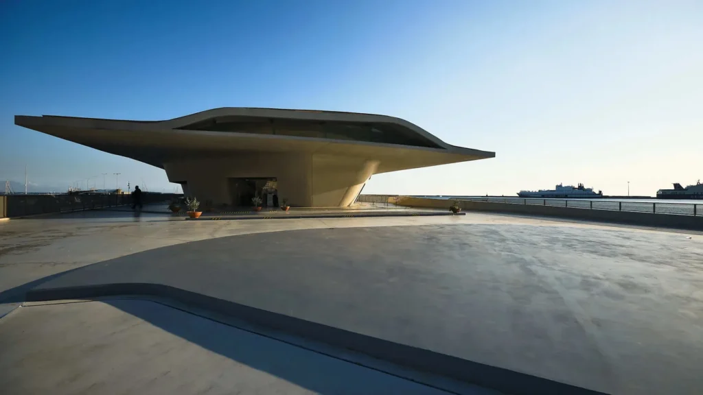 Vista exterior de la Estación Marítima de Salerno diseñada por Zaha Hadid, con su característica estructura curva de hormigón y cristal que emula una ostra marina frente al Mar Tirreno.