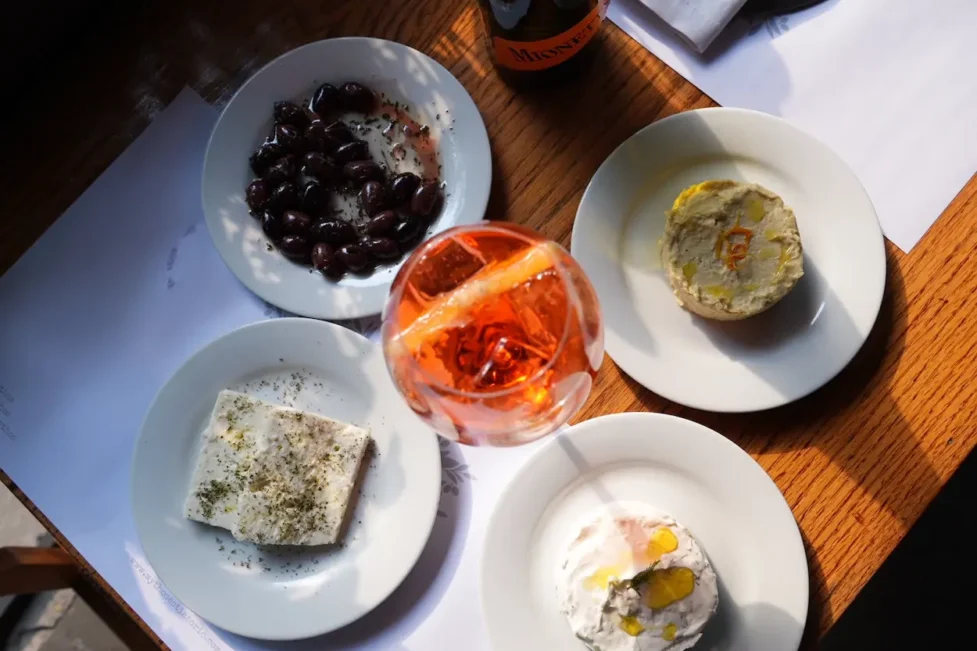 Aperitivo italiano con spritz y cocina griega en Mythos Estiatorio en Ciudad de México, con gyros, tapas mediterráneas y prosecco servido en mesa