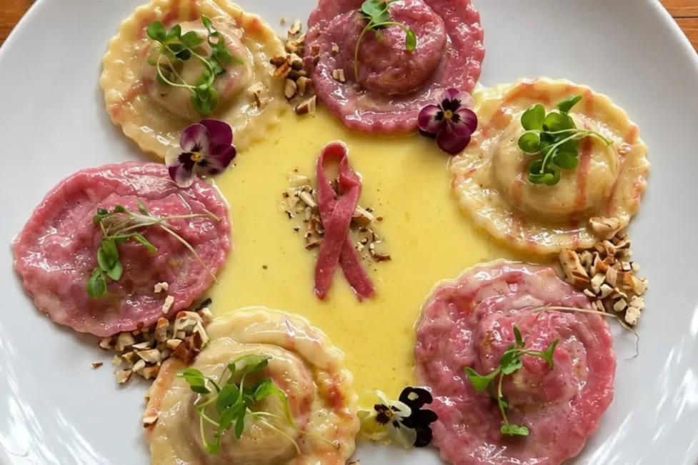 Pasta italiana rellena en color rosa con listón de concientización sobre el cáncer de mama.